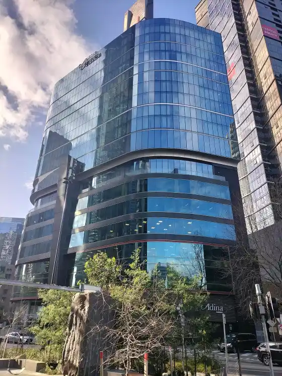 The curved glass front of Adina Melbourne Southbank on City Road