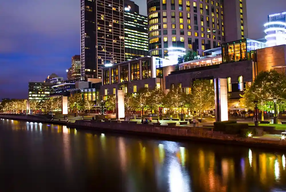 The Crown complex lit up at night along the Yarra riverside promenade