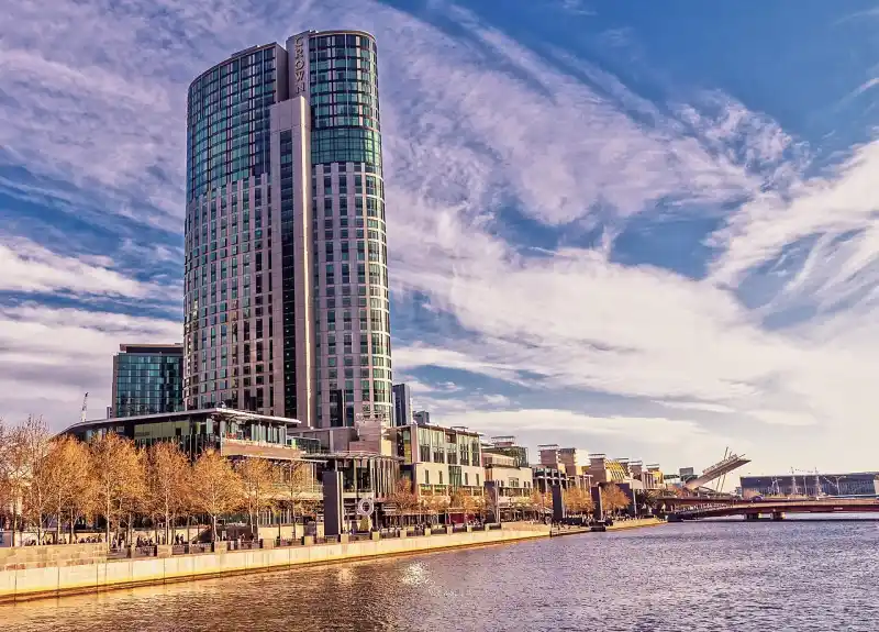 The round glass tower of Crown Towers above the Yarra riverside promenade