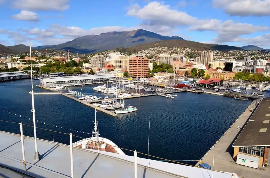 Sullivans Cove in Hobart with boats at the piers, the city skyline and kunanyi / Mount Wellington behind